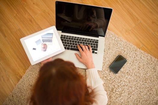 Pretty woman lying on floor using technology at Chritmas at home in the living room