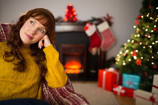 Beauty redhead thinking and relaxing at christmas at home in the living room