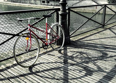 Vintage red bicycle on Pont des Arts in Paris, France