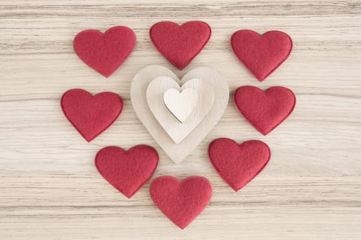 valentine's wooden and fabric hearts on a wooden background , valentine's day , day valentine postcard with space for text