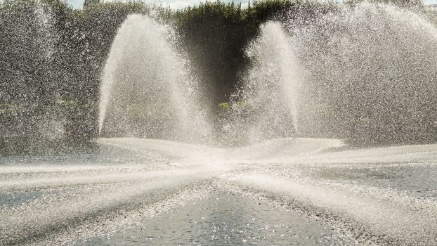 High pressured water gushing out of a pipes creating a beautiful water fountain