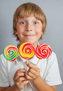 child boy eating lollipop isolated