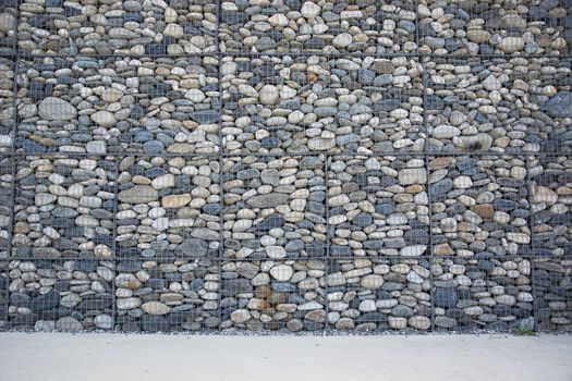 Empty wall made of stones and concrete pavement, horizontal orientation