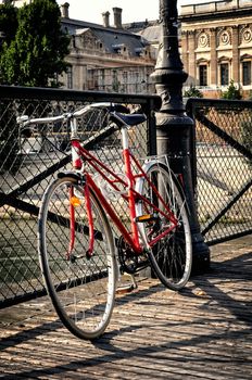 Vintage red bicycle on Pont des Arts in Paris, France