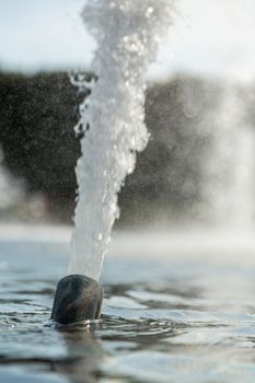 High pressured water gushing out of a pipe in a fountain