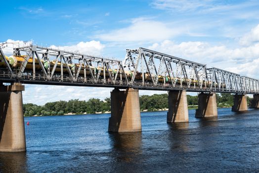 Petrivskiy railroad bridge in Kyiv across the Dnieper with freight train on it.