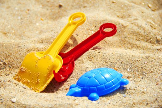 shovel and rake in the sand on the beach