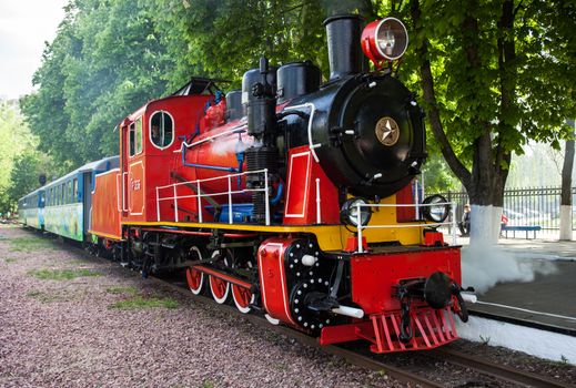 Steam locomotive blowing off the steam at the station.