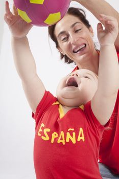 blonde baby sixteen month old and mother with red shirt of Spanish soccer team with ball