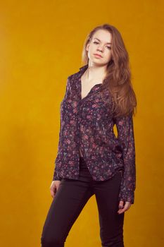 portrait of a beautiful  girl on a background of orange wall