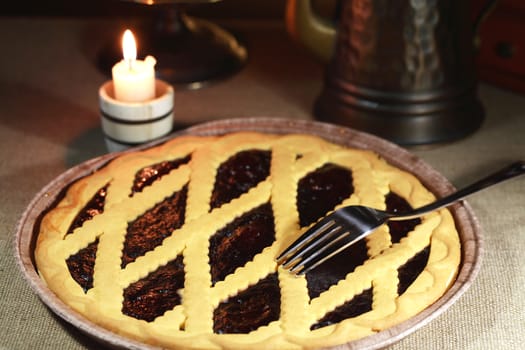 Dessert still life. Freshness homemade blueberry pie near lighting candle on dark background