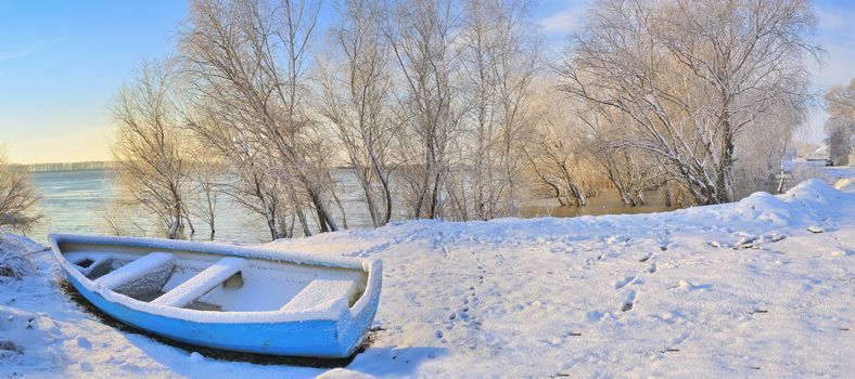 blue boat on danube river in winter time