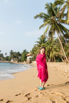 Little girl in pareo at ocean beach, Beruwala, Sri Lanka