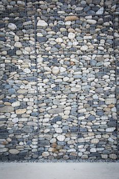 Empty wall made of stones and concrete pavement, vertical orientation