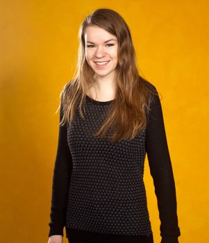 portrait of a beautiful  girl on a background of orange wall