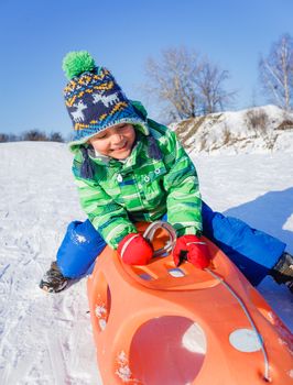 Winter, play, fun - Cute little boy having fun with sled in winter park