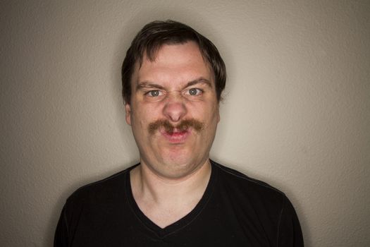 Arched mustached man not looking very happy
