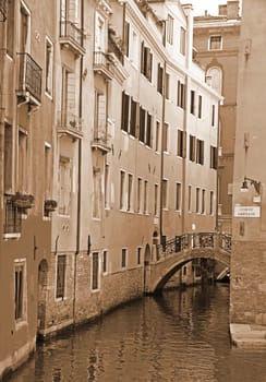 Italy. Venice. Romantic canal with bridge among old colorful brick houses. In Sepia toned. Retro style 