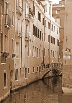 Italy. Venice. Romantic canal with bridge among old colorful brick houses. In Sepia toned. Retro style 