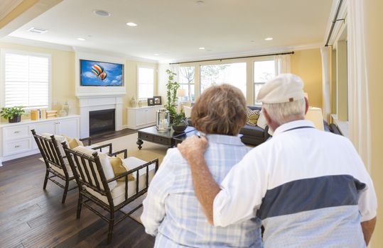 Affectionate Senior Couple Overlooking A Beautiful Custom Living Room.