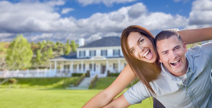 Playful Young Military Couple Outside A Beautiful New Home.