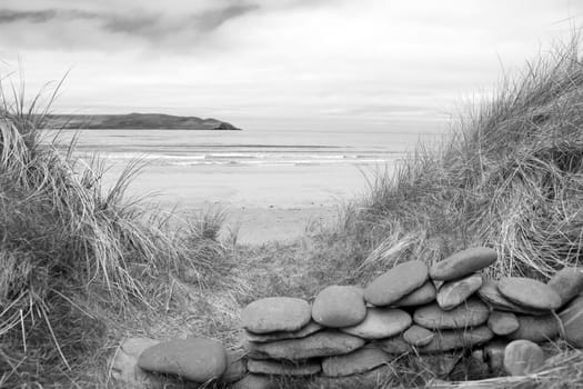 stone wall shelter on a beautiful beach at the maharees county Kerry Ireland in black and white