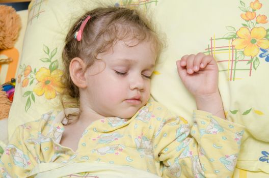 Three year old girl sweetly asleep in his crib in the nursery