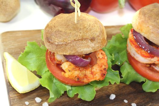 colorful healthy delicious shrimp burgers with tomatoes, red onion and lettuce