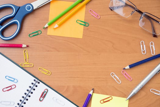 scissors, glasses, paper clips, pen, pencil,notebook on wooden surface