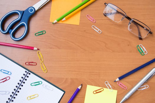 scissors, glasses, paper clips, pen, pencil,notebook on wooden surface