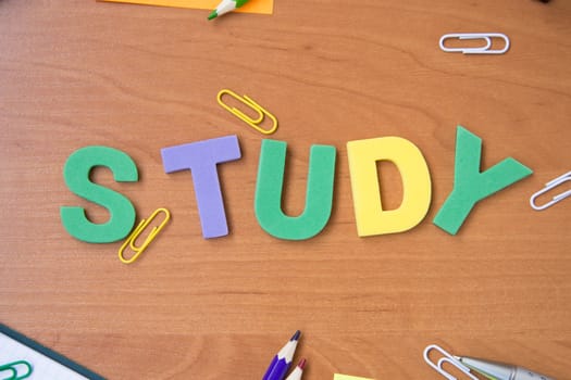 stationeries- paper clips, pen, pencil,notebook on wooden surface