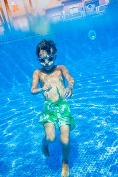 Underwater happy little boy in swimming pool