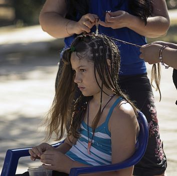 The girl braid plaits on the street.