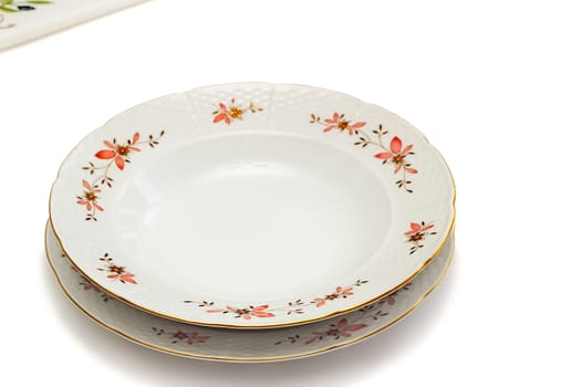 White plates with delicate ornamentation. Presented on a white background.