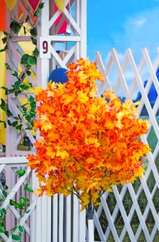 The decoration in the form of an artificial tree with autumn leaves outside the front door of the house.