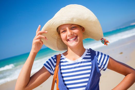 Summer vacation, lovely girl walking on the beach near water