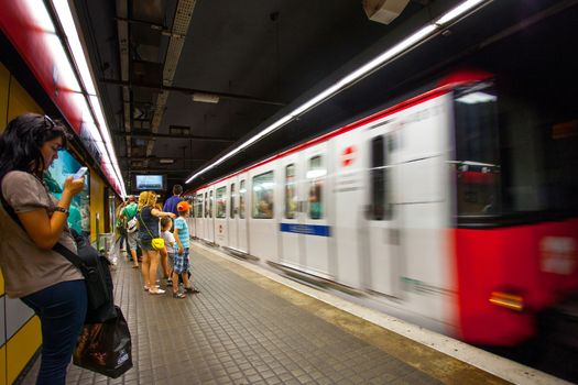 Spain, Catalonia, JUNE 14, 2013: Barcelona metro station with train in motion. ISO 1250, grain and noise. Editorial use only