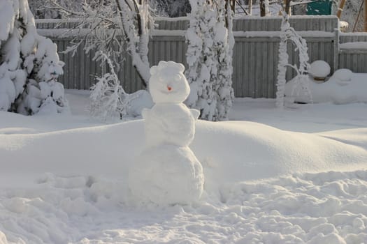 Large snowman with a carrot nose from. snowy winter