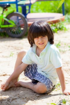 boy sitting on the sand