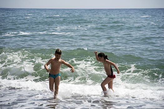 Boy and girl running on the beach.