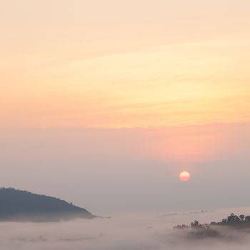 sunrise and mist covered mountains. In the morning, a cold and fog shrouded the mountains and trees.