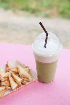 Frappe coffee and toast. Eat a snack. Coffee and bread on the table.