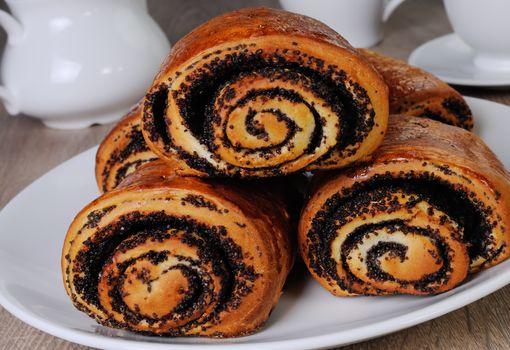 Freshly baked rolls with poppy seeds on a plate
