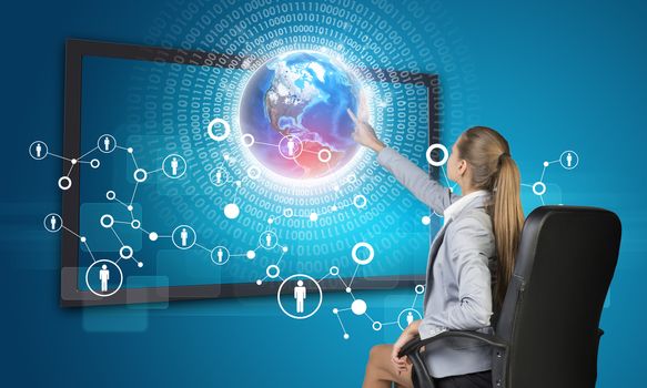Businesswoman pressing touch screen button on virtual interface with Globe and network with people icons, on blue background. Element of this image furnished by NASA