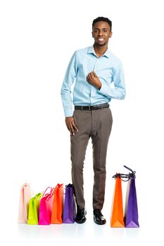 Happy african american man with shopping bags on white background. Holidays concept