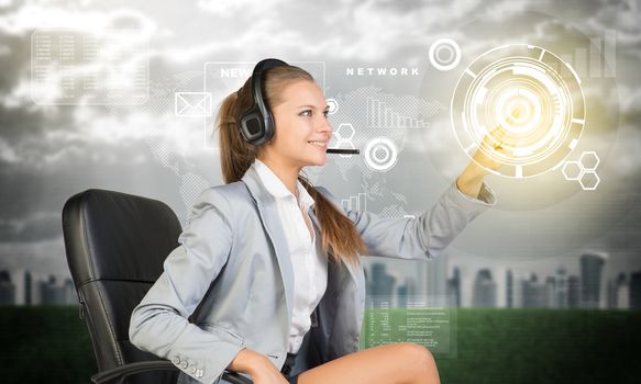 Businesswoman in headset sitting on chair using virtual interface. City, world map and graphs over cloudy sky as backdrop