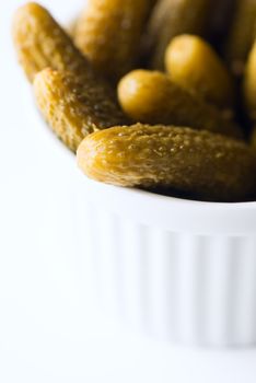 Dill pickles in bowl in soft focus. Macro with shallow dof.