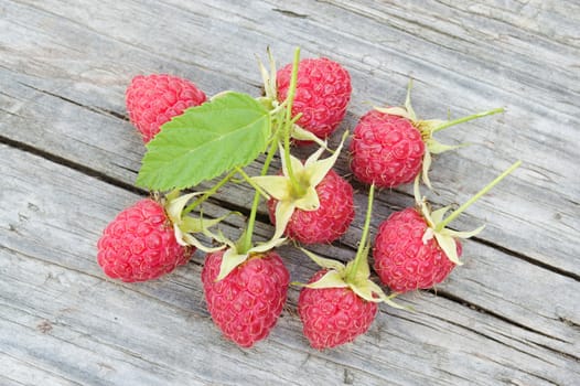 Raspberry with leaves on the old wooden board