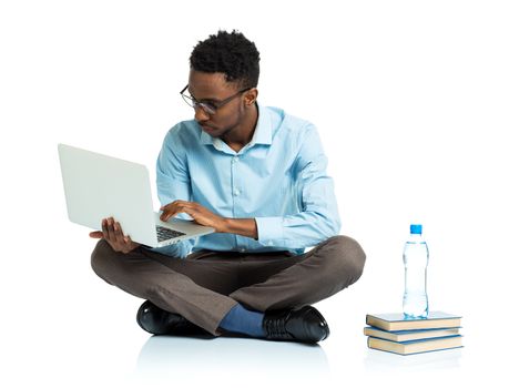 African american college student sitting with laptop on white background