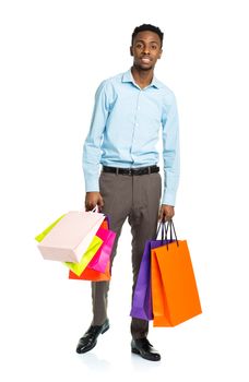 Happy african american man holding shopping bags on white background. Holidays concept